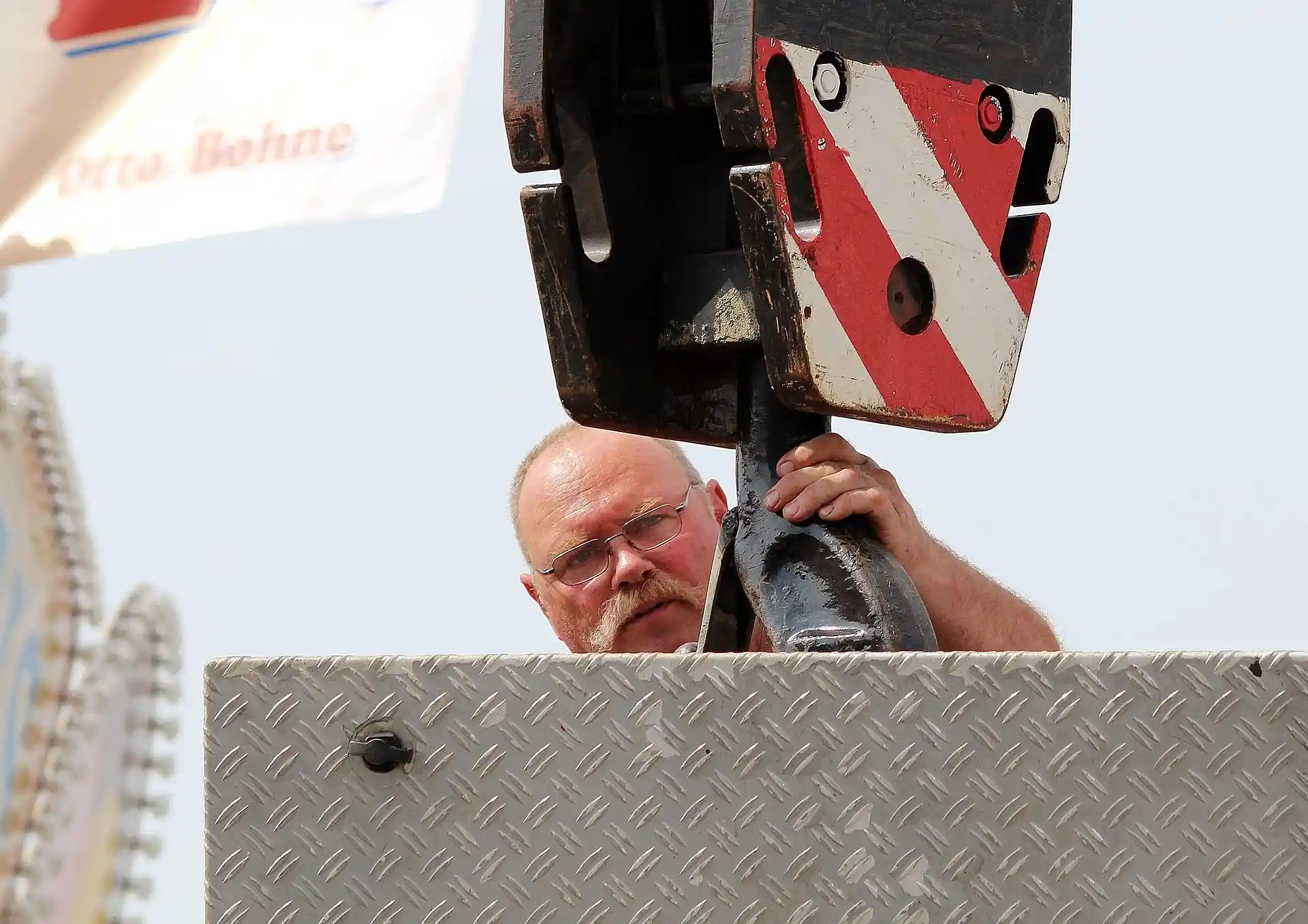 Industrial rigging worker inspecting heavy lifting equipment and crane hook